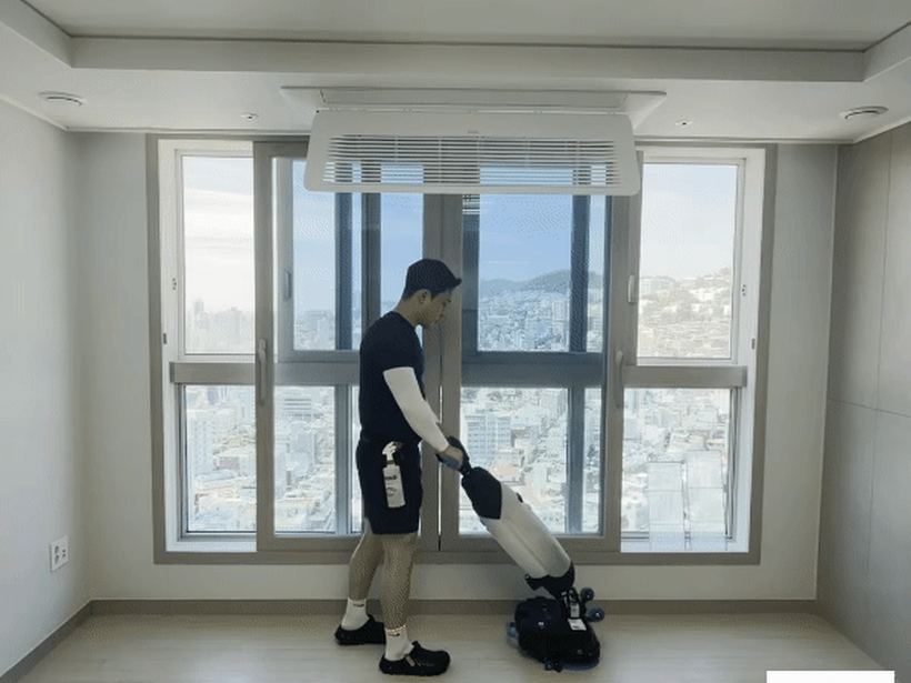 바닥 스크러버로 거실 마루를 세척하는 모습